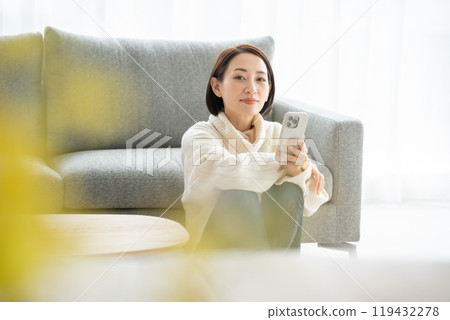 Woman operating a smartphone Woman operating a smartphone 119432278