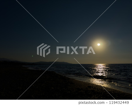 Quiet Evening on the Beach With a Radiant Moon Shining Over Calm Ocean Waters at Dusk Quiet Evening on the Beach With a Radiant Moon Shining Over Calm Ocean Waters at Dusk 119432449