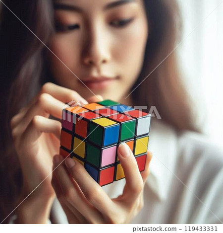 Woman looking at how to solve a Rubik's Cube Woman looking at how to solve a Rubik's Cube 119433331
