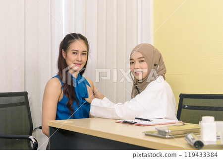 Muslim female doctor using stethoscope checking pressure and giving advice discussion to patient in the hospital. Medicine and health care concept. 119433384