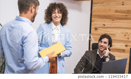 Cheerful businesswoman looking at male colleague during presentation in office Cheerful businesswoman looking at male colleague during presentation in office 119433417