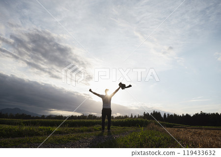 Embracing the horizon A moment of triumph in nature's light 119433632