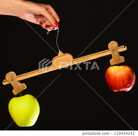 Female hand holds hanger with fruits on tips 119434242
