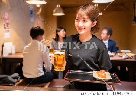 Female staff at a bar serving beer Female staff at a bar serving beer 119434762