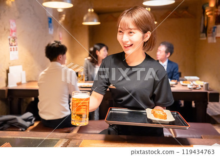 Female staff at a bar serving beer Female staff at a bar serving beer 119434763