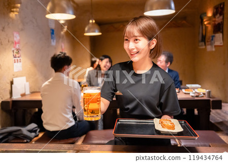 Female staff at a bar serving beer Female staff at a bar serving beer 119434764