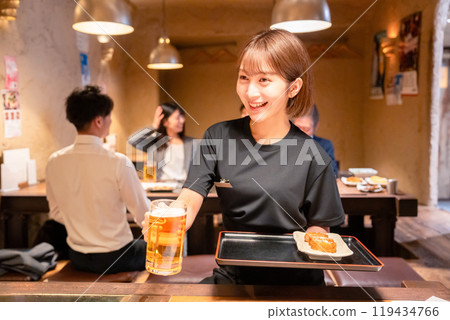 Female staff at a bar serving beer Female staff at a bar serving beer 119434766