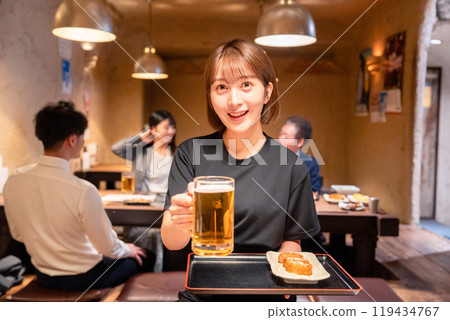 Female staff at a bar serving beer 119434767