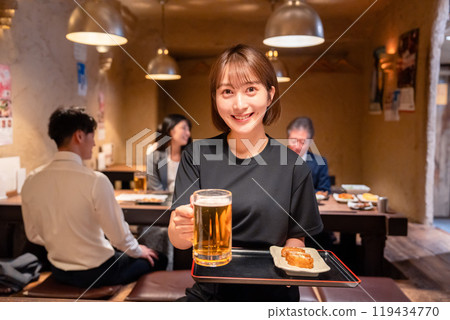 Female staff at a bar serving beer 119434770