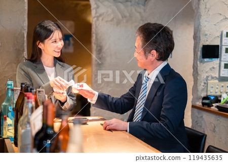 Senior businessman drinking with a woman Senior businessman drinking with a woman 119435635