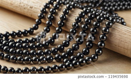 shiny and clean hematite beads on wooden background, close up photo.  119435698