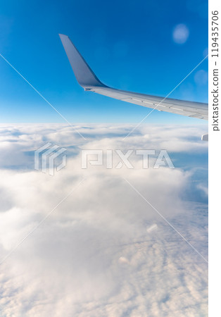 View from the airplane window at a beautiful cloudy sky and the airplane wing View from the airplane window at a beautiful cloudy sky and the airplane wing 119435706