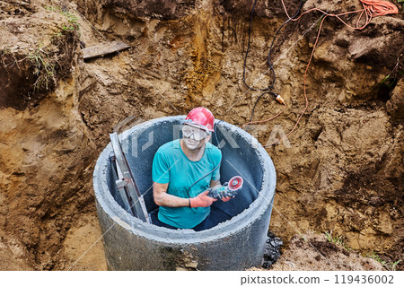 Builder face and safety glasses covered in cement dust after cutting concrete ring with diamond wheel. Builder face and safety glasses covered in cement dust after cutting concrete ring with diamond wheel. 119436002