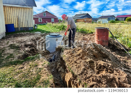 Worker buries an absorbent trench of wastewater disposal area of rural domestic sewage system. 119436013