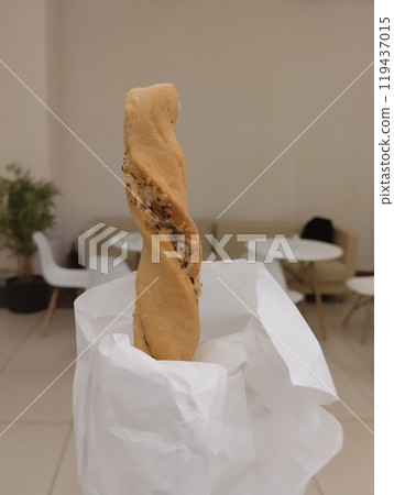 Grissini in hand in a cafe atmosphere. Homemade Plain Bread 119437015