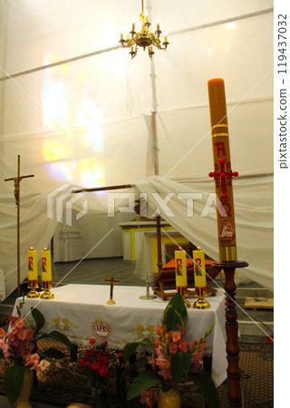 table with candles and candlestickand flowers. Preparation for the sacrament of baptism. Church atmosphere 119437032