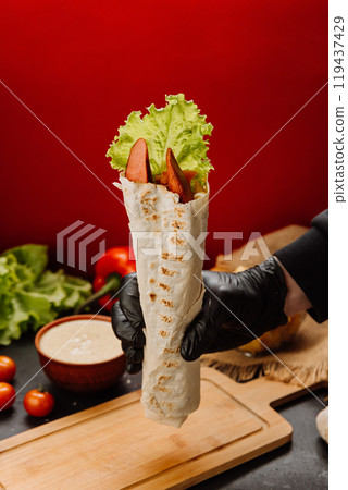 Grilled sausage wrap with fresh lettuce, a perfect quick snack or meal for on-the-go moments Grilled sausage wrap with fresh lettuce, a perfect quick snack or meal for on-the-go moments 119437429