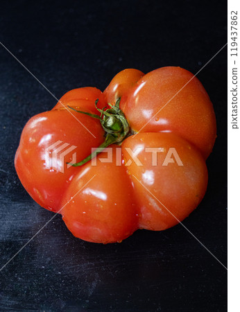 Vertical macro photo of a freshly harvested tomatoin black background. Vertical macro photo of a freshly harvested tomatoin black background. 119437862