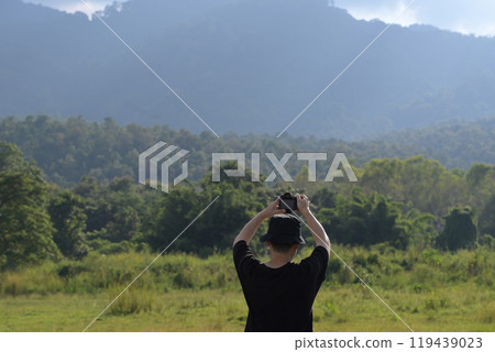 Young man photographing the beautiful landscape with his camera. Travel and outdoor activities concept 119439023