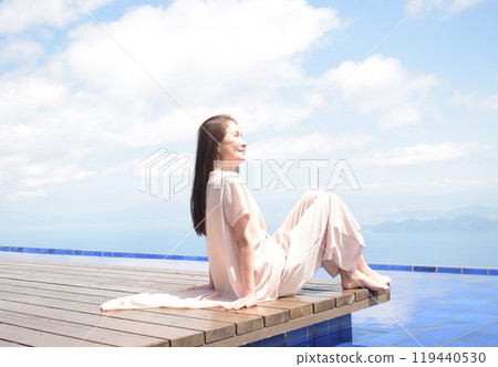 A smiling senior woman sitting on the wooden deck of Biwako Terrace 119440530
