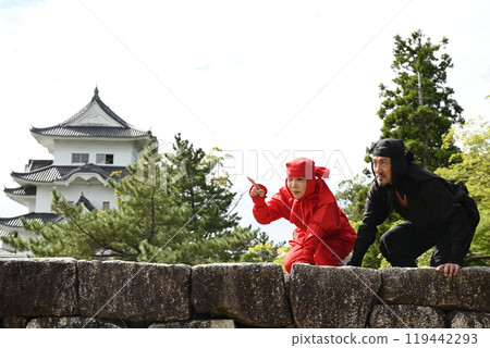 Kunoichi and Ninja aiming at each other on a stone wall 119442293