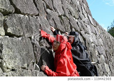Ninja and Kunoichi climbing a stone wall Ninja and Kunoichi climbing a stone wall 119442303