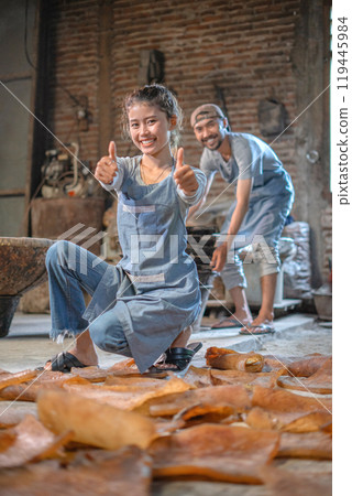 Joyful Artisans are Enthusiastically Crafting Clay in a Rustic Workshop Setting 119445984