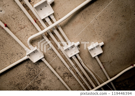 The electrical wiring at the construction site is completed and suspended from the ceiling 119446394