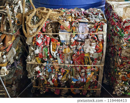 There is a large pile of crushed aluminum cans stacked on top of each other at the landfill. 119446413