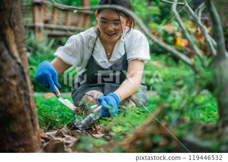 happy asian woman planting using recycled plastic bottle pot 119446532