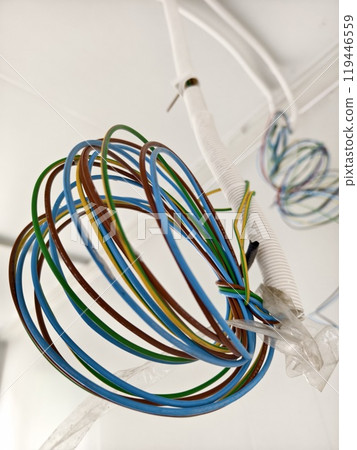 A collection of various wires is hanging down from the ceiling 119446559