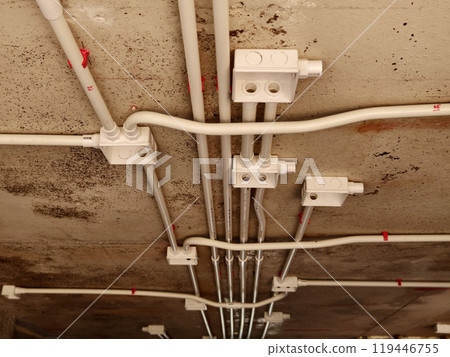 The electrical wiring at the construction site is completed and suspended from the ceiling The electrical wiring at the construction site is completed and suspended from the ceiling 119446755