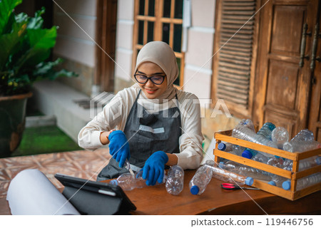 high angle view woman cutting plastic bottle for making craft 119446756