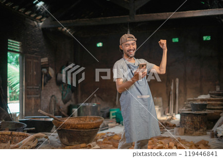 A Joyful Artisan Celebrates in a Workshop Crafting Beautiful Clay Pieces 119446841