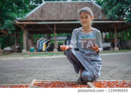 A young woman is engaged in traditional crafting with colorful materials 119446843