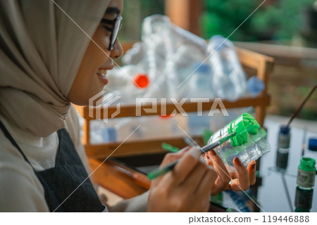 close up hijab woman coloring plastic bottle waste 119446888