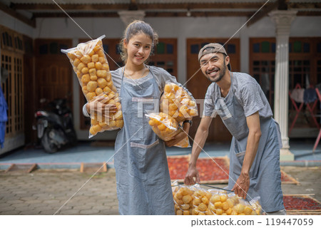 Joyful and Enthusiastic Workers are Packing Freshly Made Pastries in a Local Market Joyful and Enthusiastic Workers are Packing Freshly Made Pastries in a Local Market 119447059