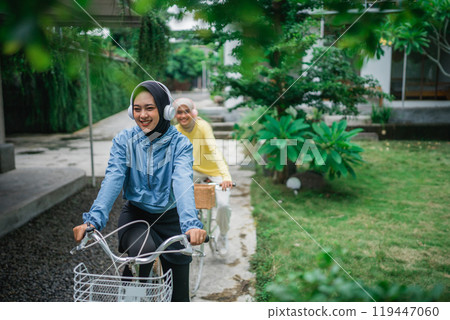 indonesian veiled women with headphones on bicycle on bike path lane indonesian veiled women with headphones on bicycle on bike path lane 119447060