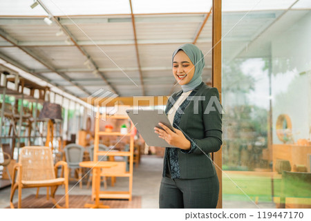 Confident Businesswoman Using a Tablet in a Modern and Stylish Workspace Environment Confident Businesswoman Using a Tablet in a Modern and Stylish Workspace Environment 119447170