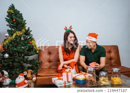 A joyous and festive couple joyfully celebrating Christmas with gifts, love, and cheer A joyous and festive couple joyfully celebrating Christmas with gifts, love, and cheer 119447187