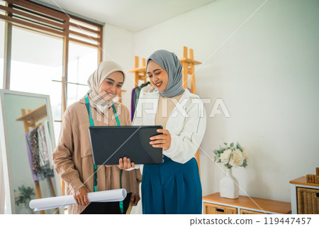 Two Women Working Together in a Bright Studio, Collaborating on Fashion Design and Ideas Two Women Working Together in a Bright Studio, Collaborating on Fashion Design and Ideas 119447457