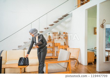 young woman wearing a blazer picks up a bag 119447709