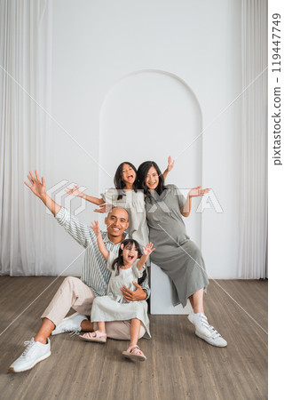 A cheerful family is happily posing together for a picture in a room 119447749