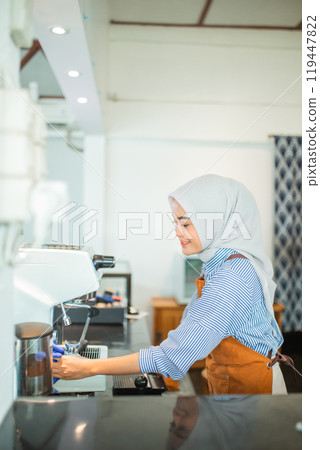 Asian veiled woman cafe owner cleaning drip coffee maker at cafe 119447822