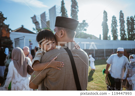 A father lovingly embraces his child at a vibrant community event, celebrating joy 119447993
