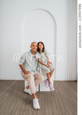 A man and a girl sit next to each other on a bench 119447996