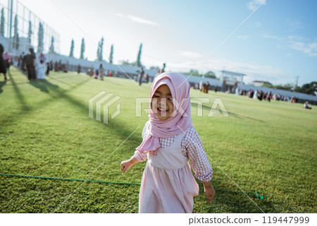 A Joyful Child Excitedly Running on a Bright and Sunny Day in the Vibrant Park 119447999