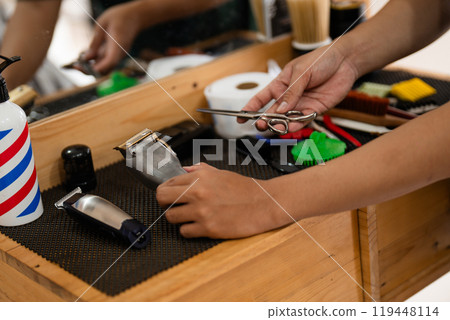 An individual holds sharp scissors while standing in front of a mirror An individual holds sharp scissors while standing in front of a mirror 119448114