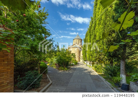 Garden of the Metekhi Church in Tbilisi, Georgia, with greenery and clear skies on a sunny day 119448195