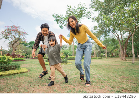 little boy holding hands with mom and dad while running together 119448280